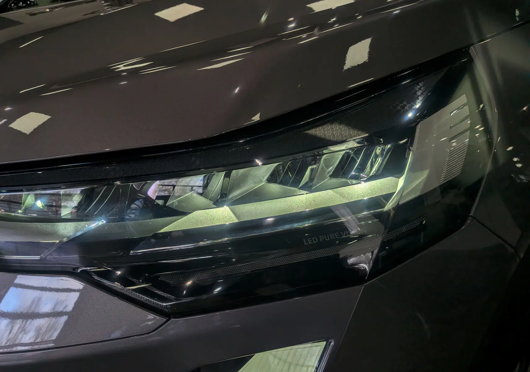 Gros plan sur le phare avant droit LED du Renault Symbioz E-TECH gris Cassiopé, soulignant son design moderne et précis.