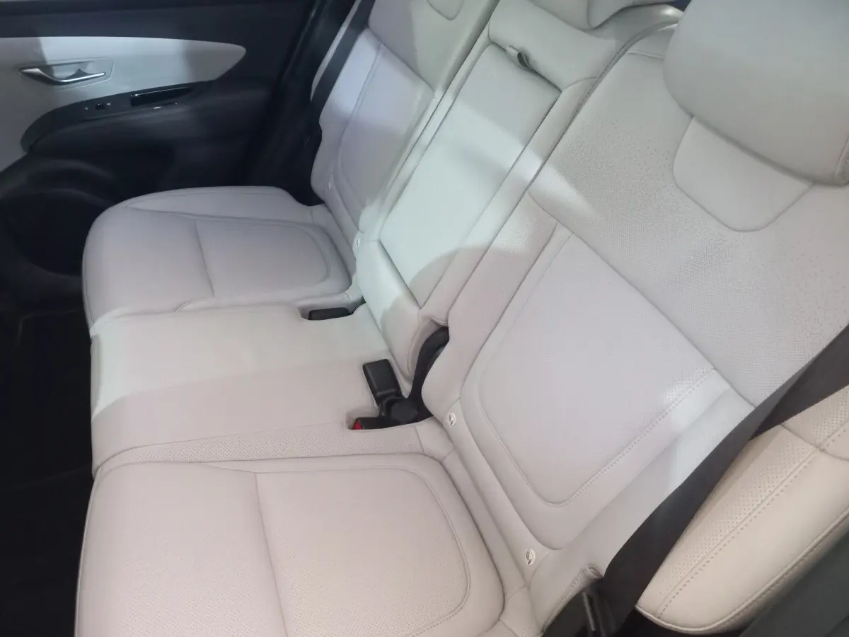 Vue intérieure montrant les sièges arrière en cuir beige clair du Hyundai Tucson 2023, avec ceinture de sécurité noire visible.