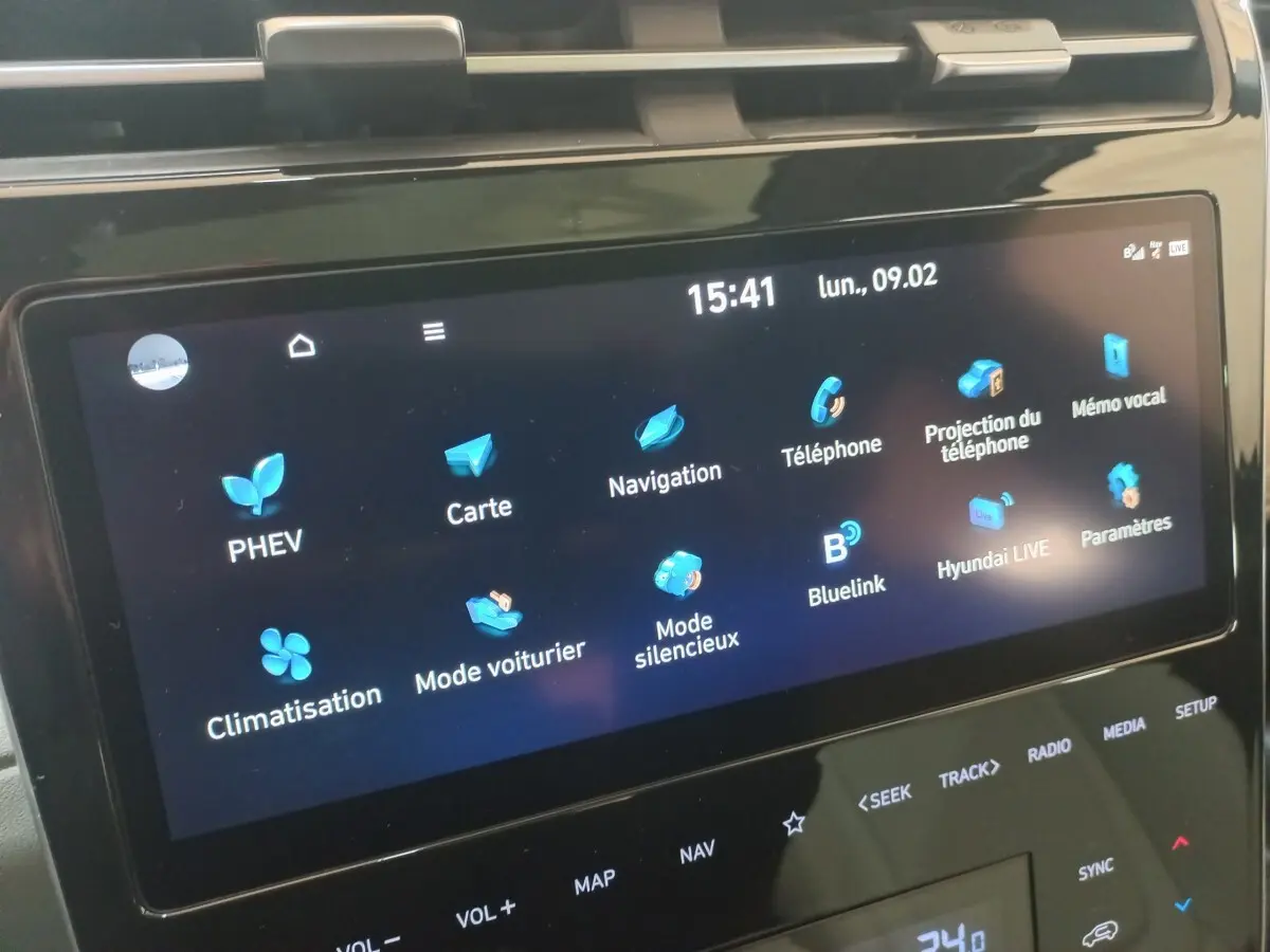 Écran tactile central du Hyundai Tucson gris foncé 2023 affichant les menus PHEV, navigation et climatisation.