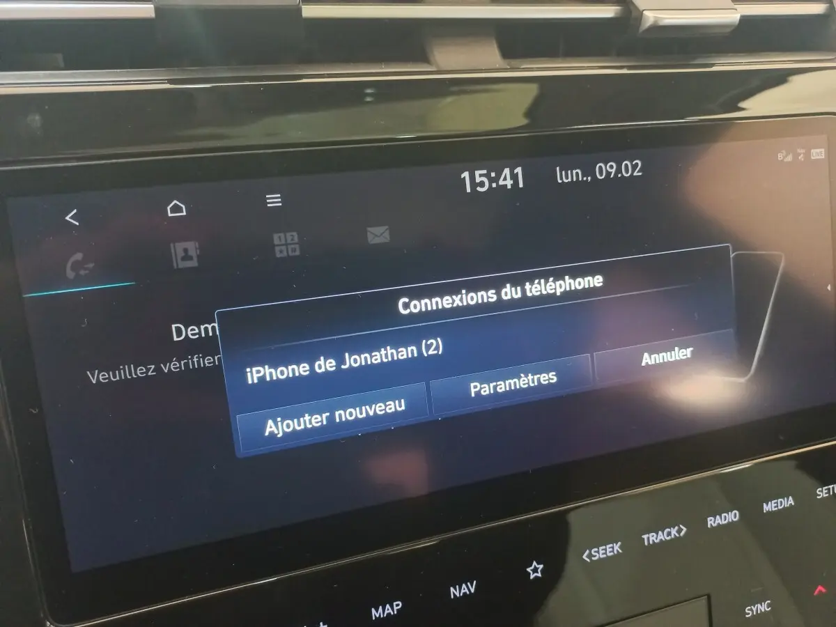 Écran tactile central du Hyundai Tucson gris foncé 2023 affichant la connexion Bluetooth d’un iPhone.