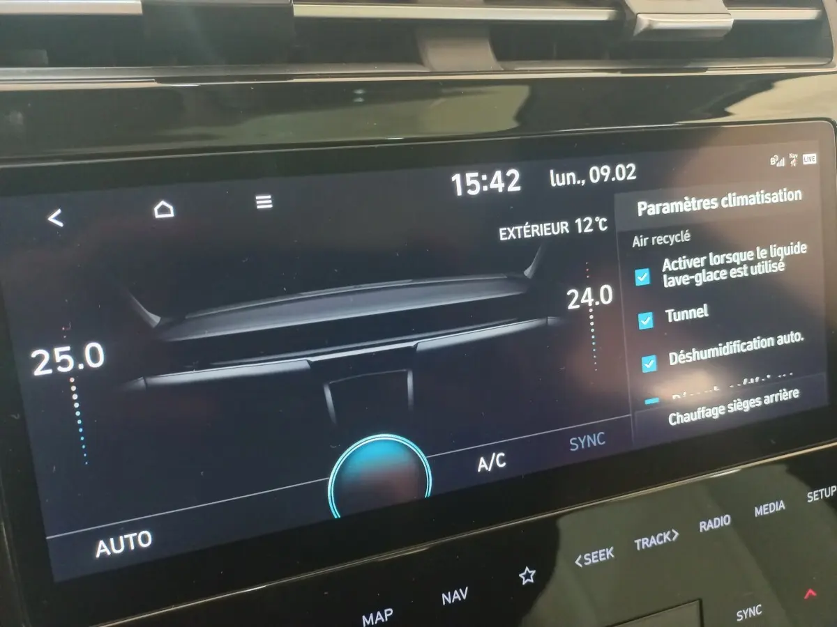 Écran tactile central du Hyundai Tucson 2023 affichant les paramètres de climatisation et la température extérieure à 12°C.