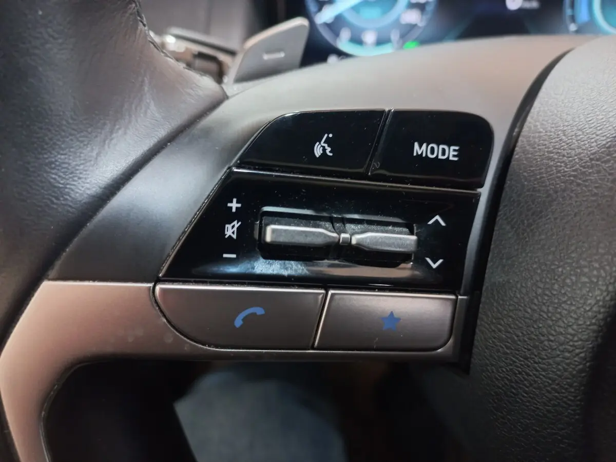 Gros plan sur les commandes gauche du volant du Hyundai Tucson gris foncé, boutons mode, volume et appel.