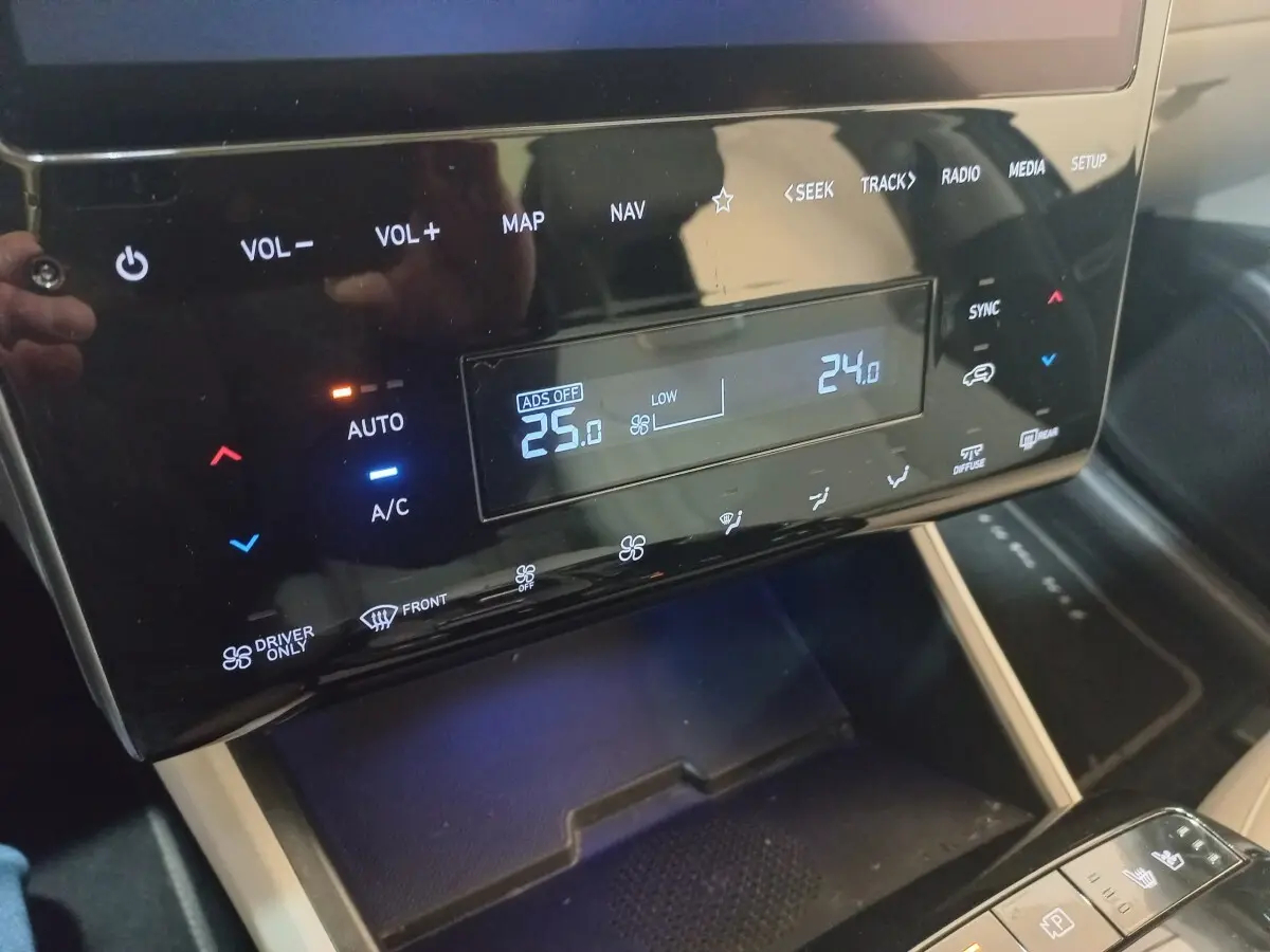 Vue rapprochée du tableau de bord tactile noir du Hyundai Tucson gris foncé 2023 avec commandes climatisation digitales.