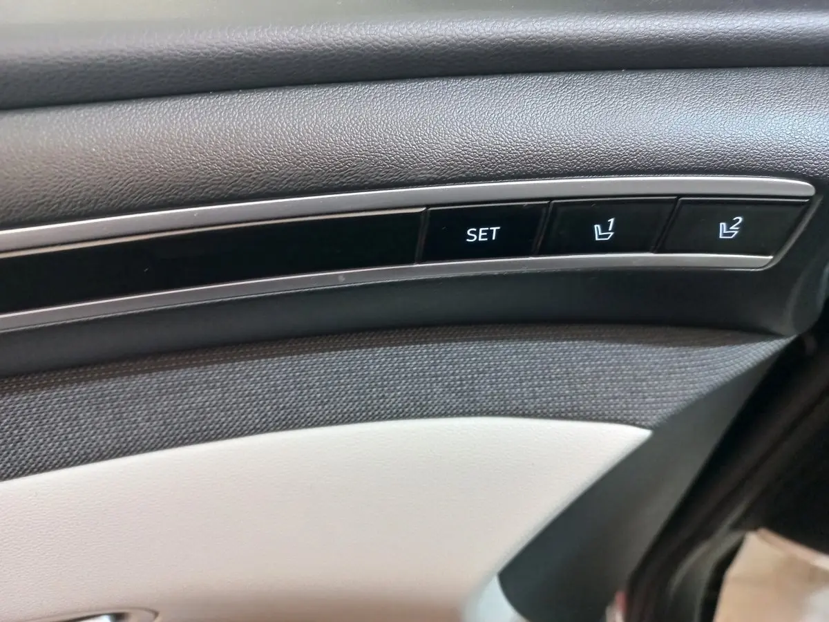 Gros plan sur les boutons de réglage mémoire des sièges sur la porte intérieure d’un Hyundai Tucson gris foncé 2023.
