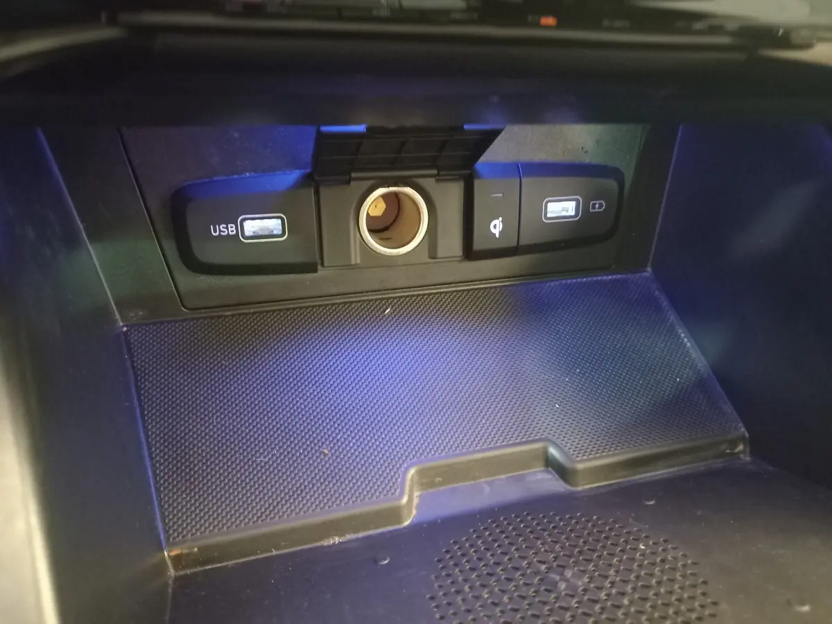 Gros plan sur la zone de recharge avec ports USB et prise 12V du Hyundai Tucson hybride rechargeable 2023.