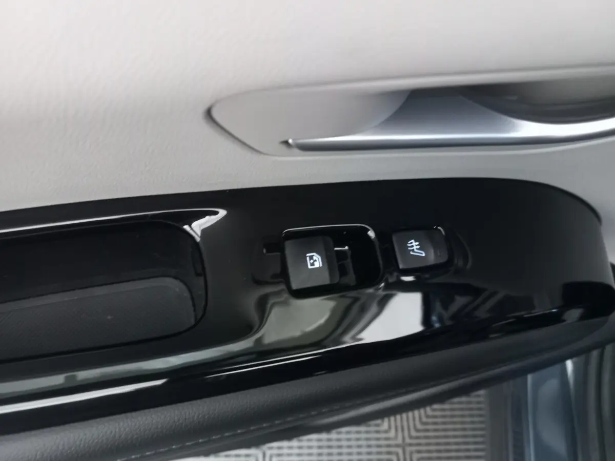 Gros plan sur les commandes de verrouillage et chauffage du siège sur la porte côté conducteur du Hyundai Tucson gris foncé 2023.
