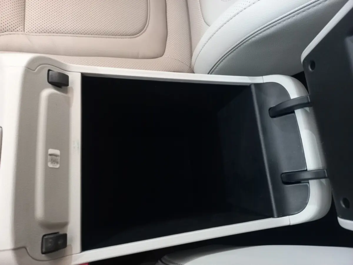 Gros plan sur le rangement central ouvert avec intérieur noir et sellerie cuir beige clair dans un Hyundai Tucson 2023.