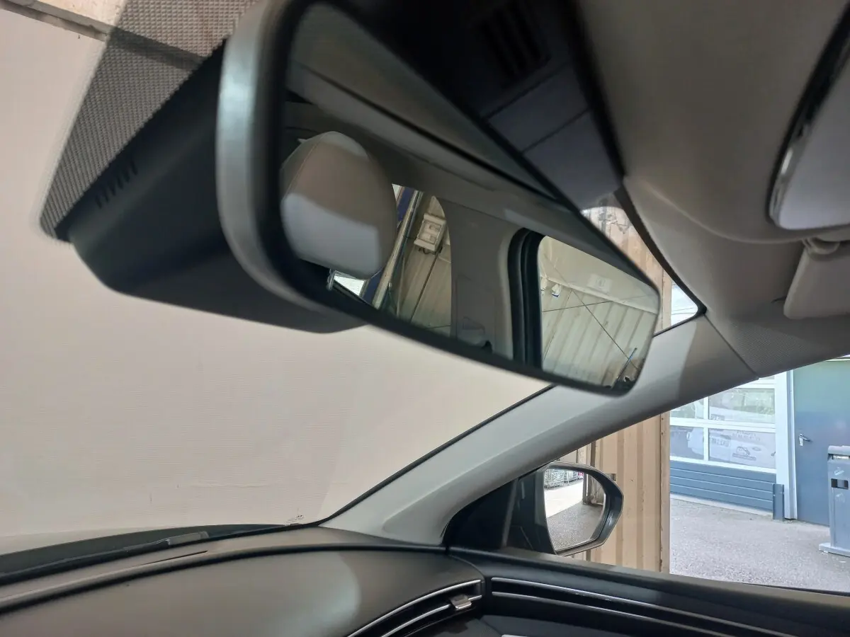 Vue intérieure du rétroviseur central du Hyundai Tucson 2023 gris foncé, avec partie du tableau de bord et siège visible.