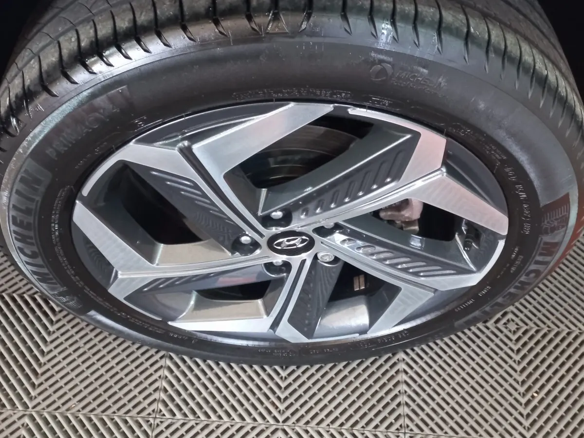 Gros plan sur la jante alliage bicolore et le pneu Michelin d’un Hyundai Tucson gris foncé 2023.