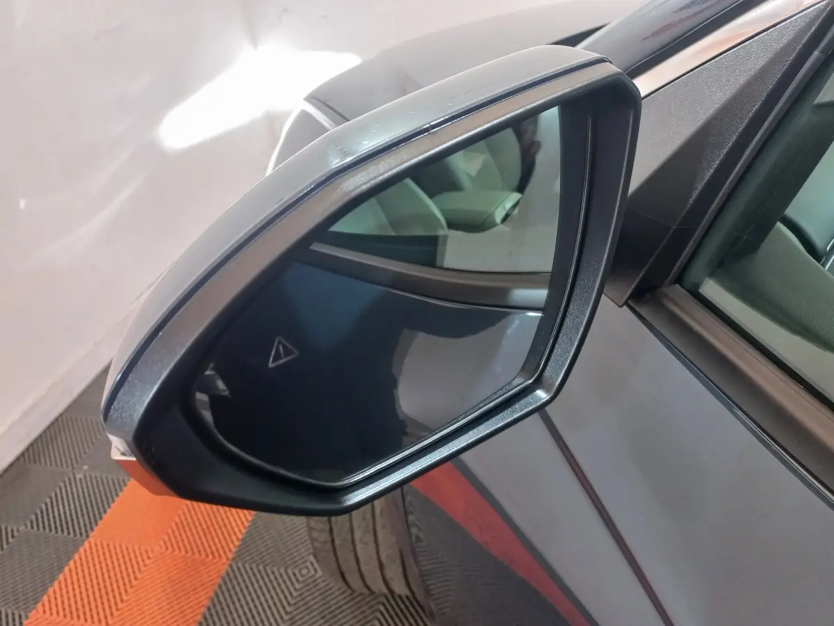Rétroviseur côté droit gris foncé du Hyundai Tucson 2023, avec angle mort et reflet intérieur visible.