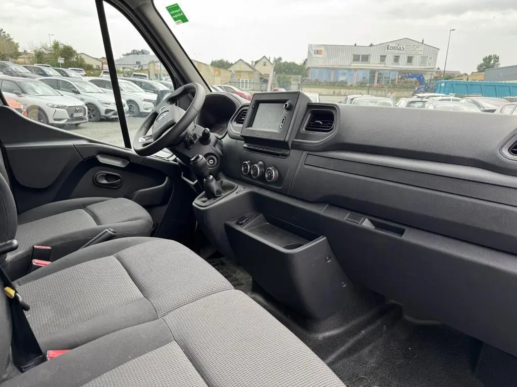 Intérieur cabine Renault Master 2022 vu côté passager, sièges tissu gris et tableau de bord avec écran tactile.