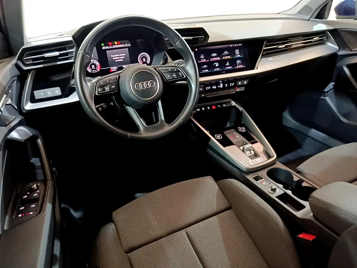 Intérieur Audi A3 35 TFSI 2023 vu côté conducteur, volant cuir, tableau de bord digital et écran tactile central.