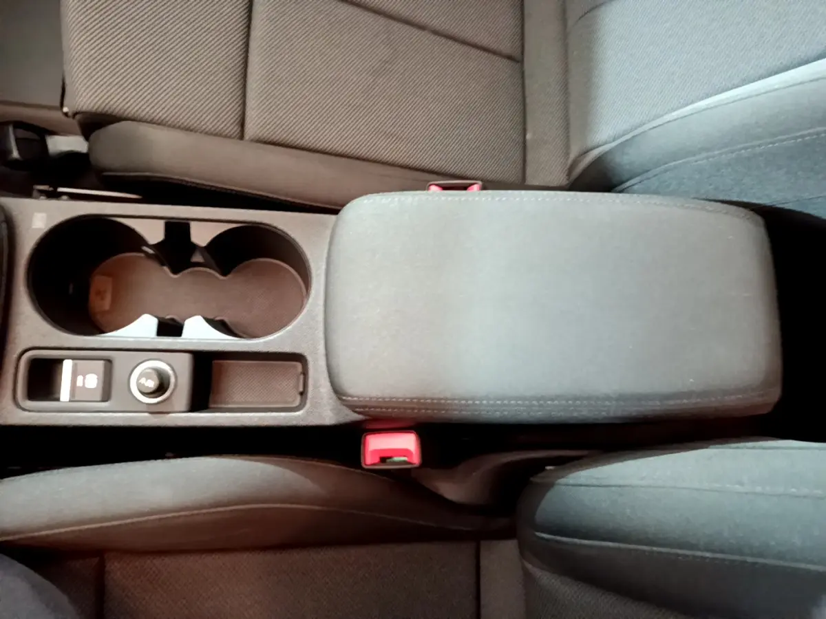 Vue plongeante sur la console centrale noire de l'Audi A3 35 TFSI 2023 avec accoudoir et porte-gobelets.