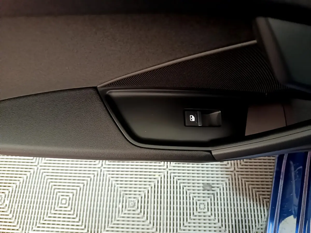 Bouton de verrouillage de porte sur la garniture intérieure côté gauche d'une Audi A3 bleu 2023.