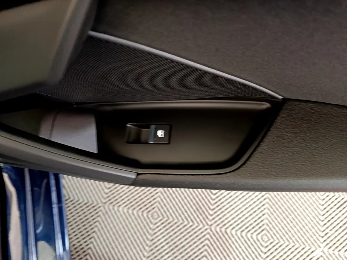 Détail de la commande de lève-vitre sur la porte côté gauche d'une Audi A3 bleu 2023 vue intérieure
