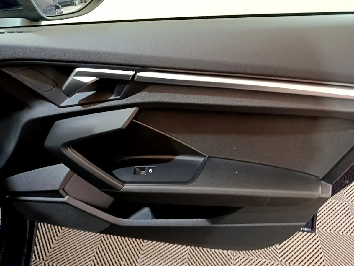 Vue rapprochée de la porte côté gauche de l'Audi A3 35 TFSI 2023 avec garniture noire et insert argenté.