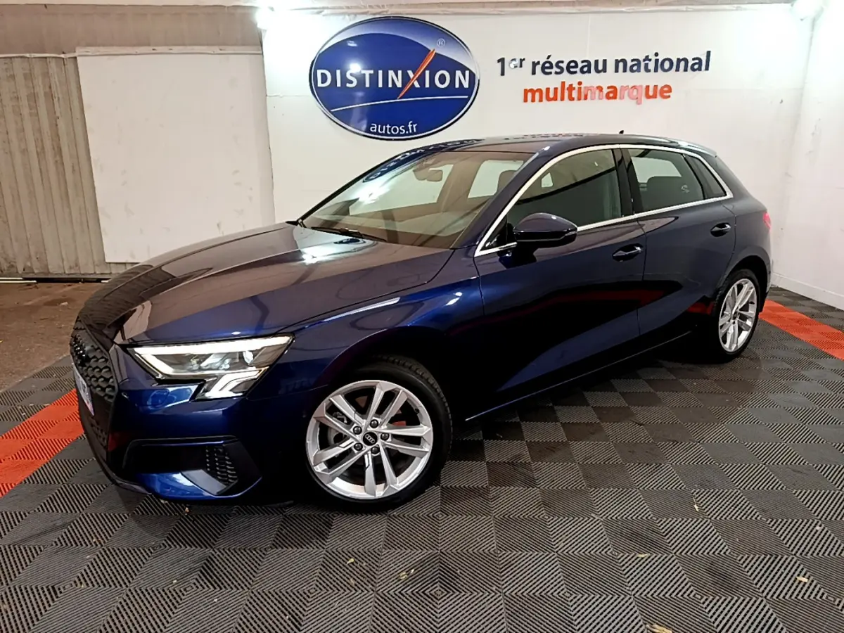 Audi A3 35 TFSI bleu en 3/4 avant droit, avec phares LED et jantes alliage visibles en intérieur showroom
