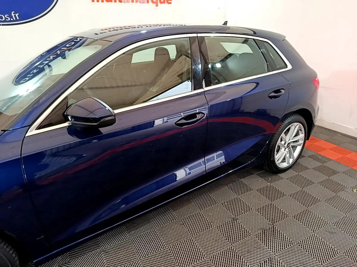 Vue latérale côté gauche d'une Audi A3 bleu profond avec jantes alliage et rétroviseurs assortis.