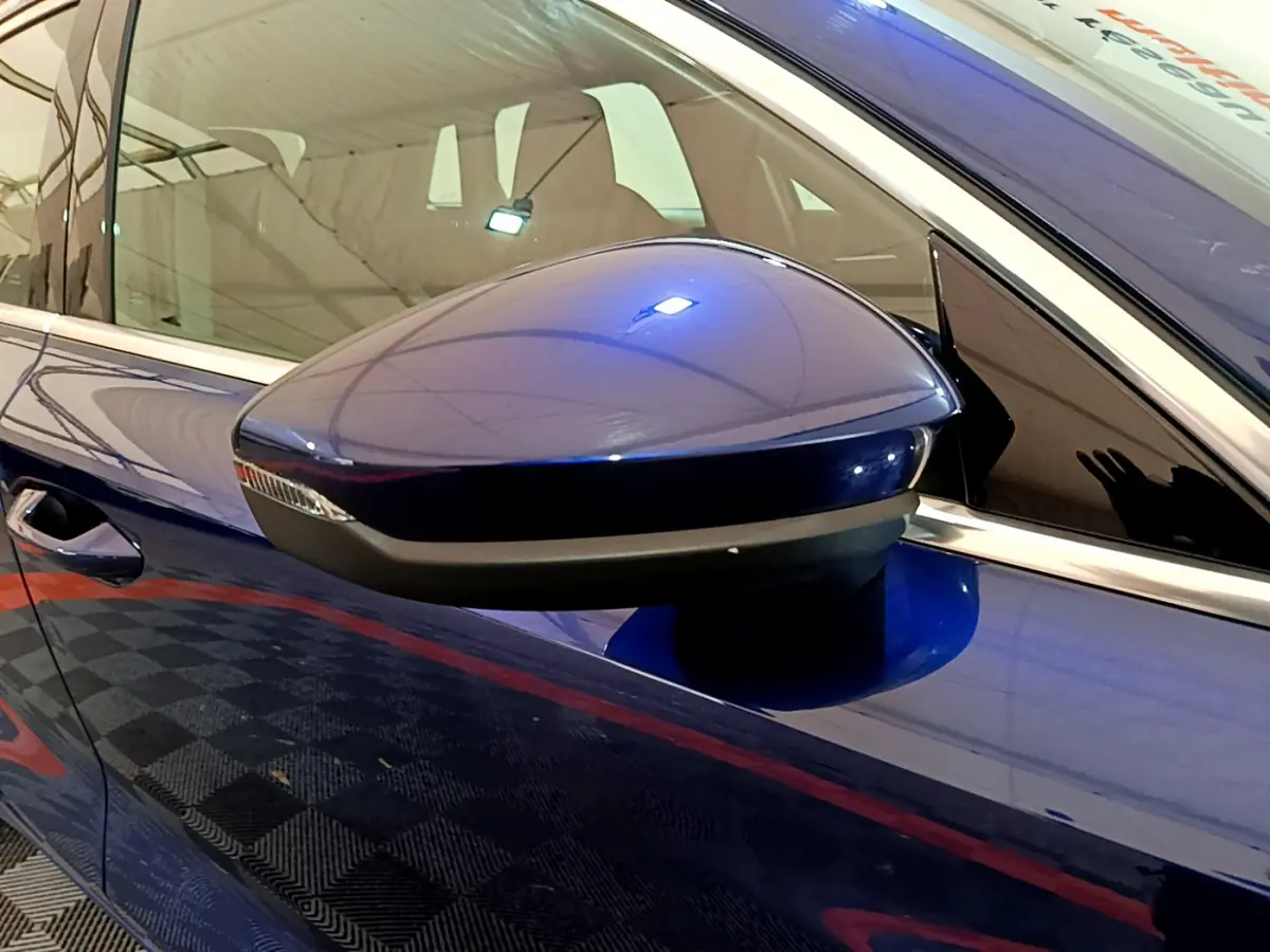 Rétroviseur côté gauche bleu brillant de l'Audi A3 35 TFSI 2023 avec clignotant intégré, vue rapprochée.