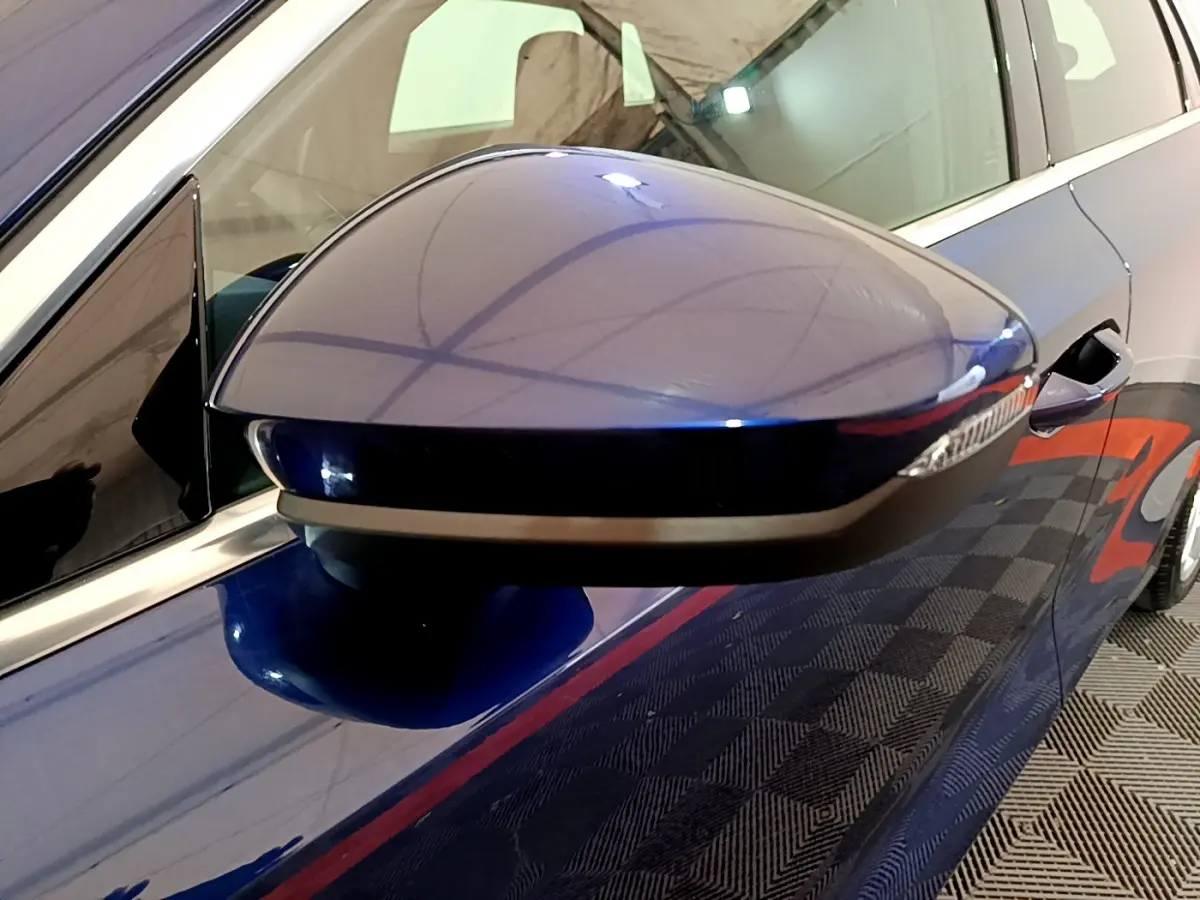 Gros plan sur le rétroviseur droit bleu de l'Audi A3 35 TFSI 150 MHEV 2023 avec clignotant intégré.