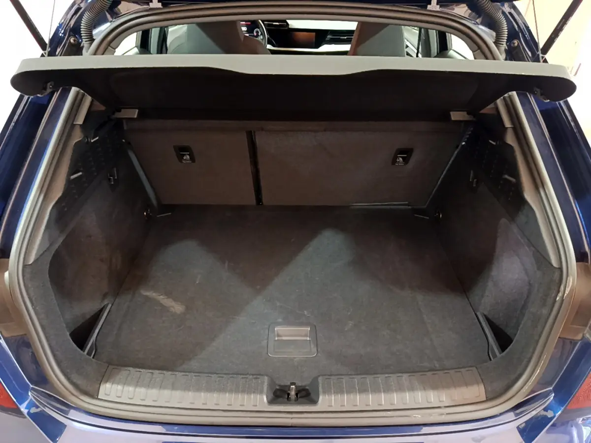 Coffre ouvert vu de l'arrière d'une Audi A3 35 TFSI bleu, montrant l'espace de chargement vide et la tablette de séparation.