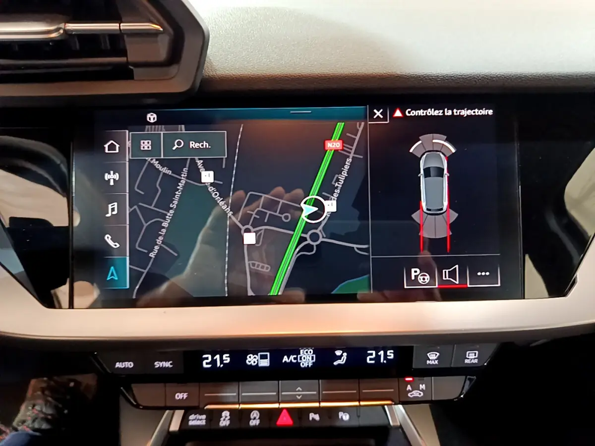 Écran tactile central de navigation et aide au stationnement dans l'habitacle de l'Audi A3 bleu 2023.