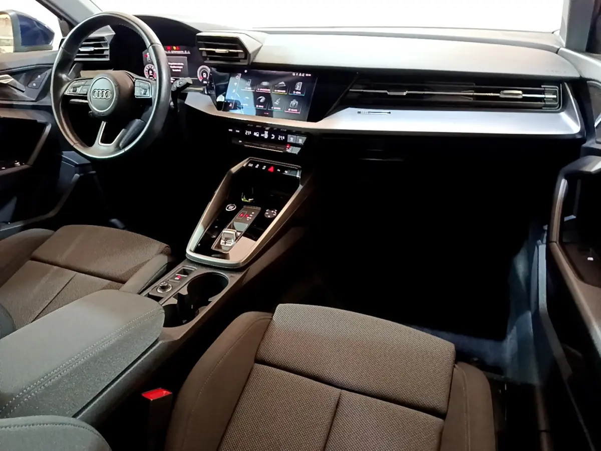 Intérieur avant de l'Audi A3 35 TFSI bleu, vue côté conducteur sur tableau de bord et console centrale moderne