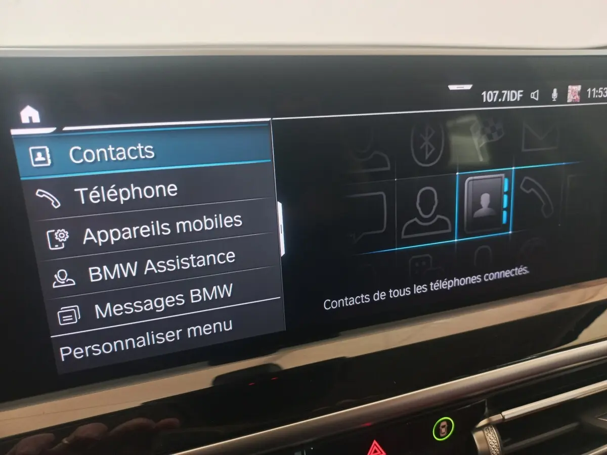 Écran tactile central du BMW X3 blanc 2022 affichant le menu contacts et options connectées.