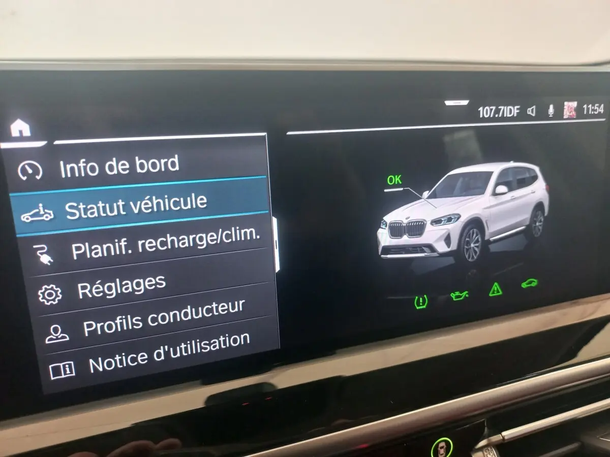 Écran tactile affichant le statut véhicule d'un BMW X3 blanc en vue 3/4 avant droite avec icône OK verte.