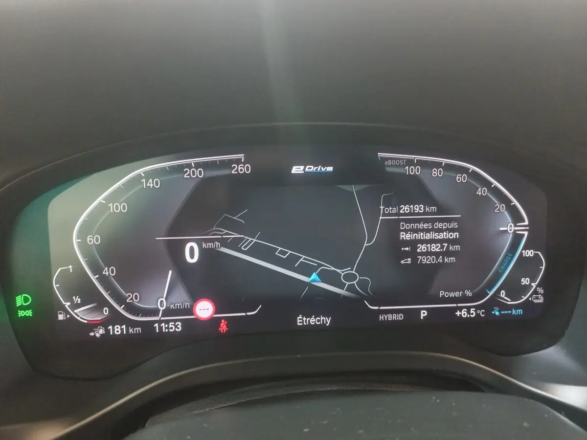 Tableau de bord numérique de BMW X3 hybride rechargeable, affichage 3D de navigation et compteurs digitaux.