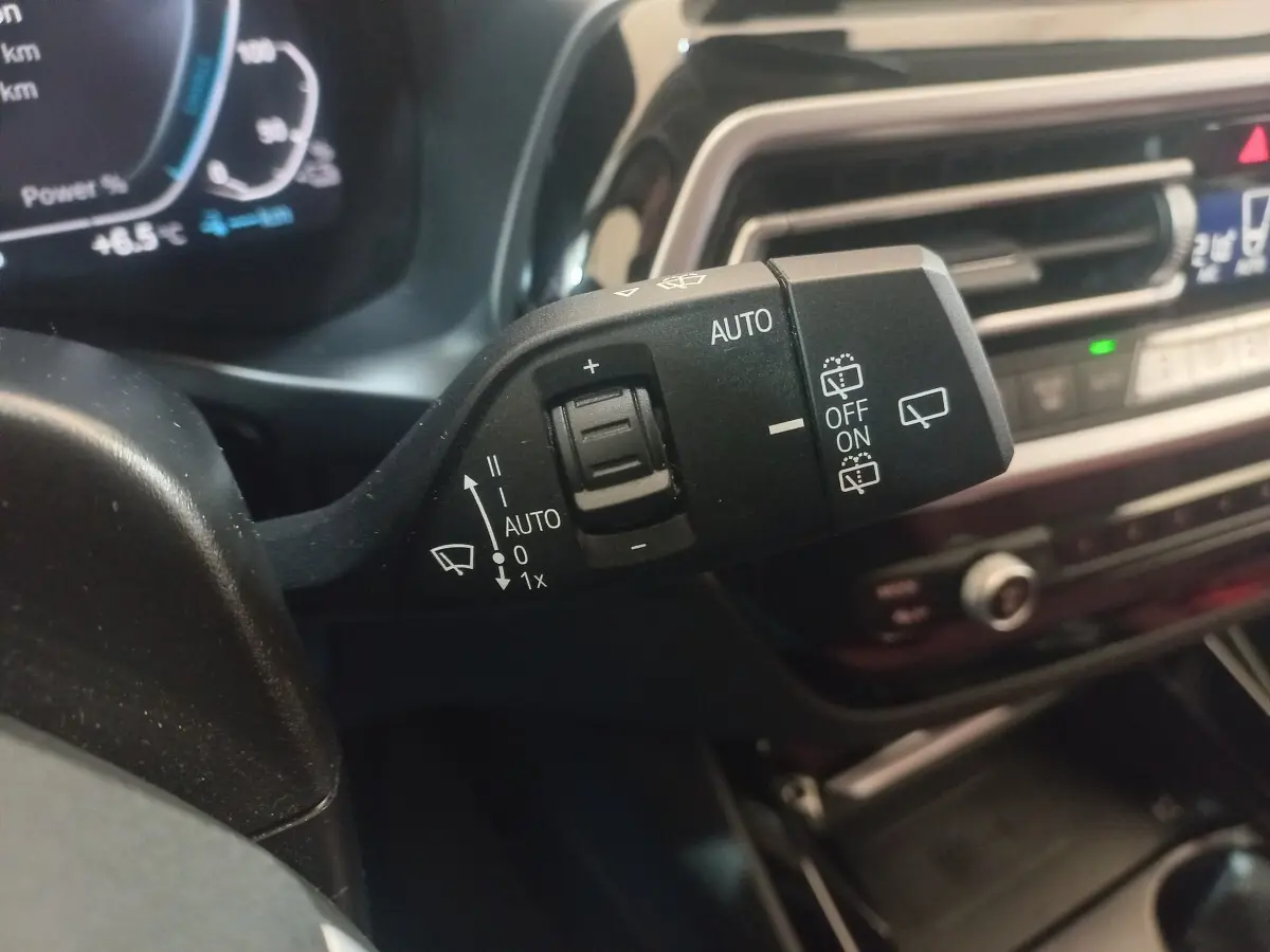 Gros plan sur la commande d’essuie-glace côté gauche du tableau de bord d’un BMW X3 blanc hybride rechargeable 2022.