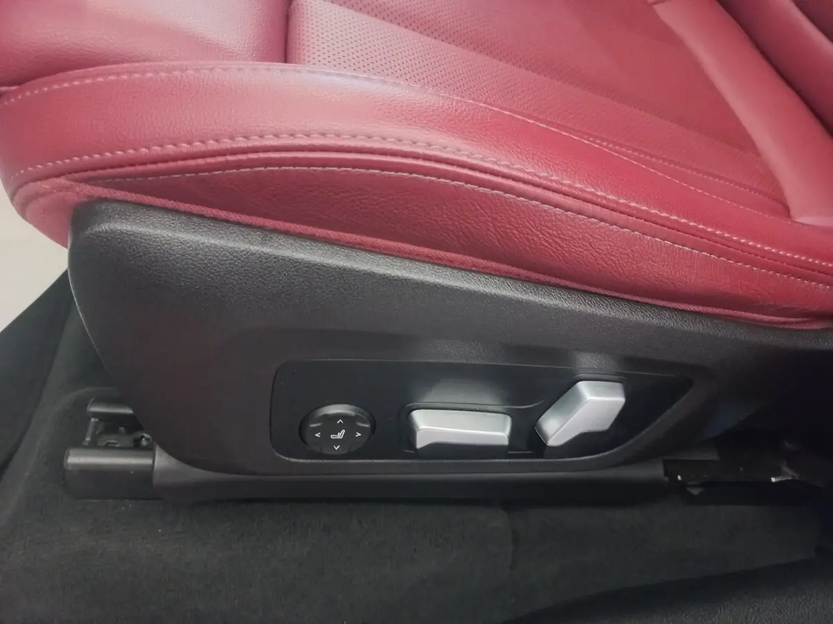 Gros plan sur les commandes électriques du siège avant rouge du BMW X3 xDrive30e 2022.