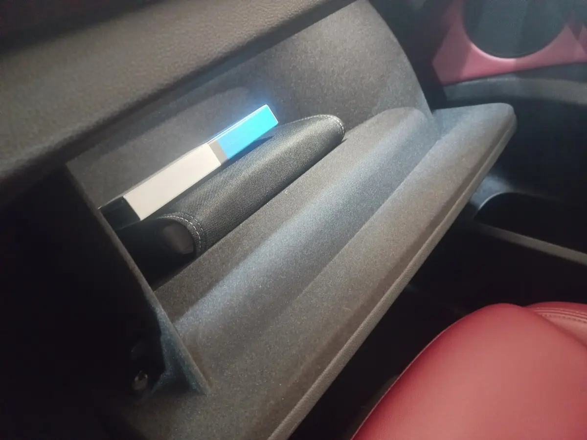 Gant de boîte à gants ouvert côté passager intérieur d'une BMW X3 xDrive30e 2022 avec siège en cuir rouge visible.