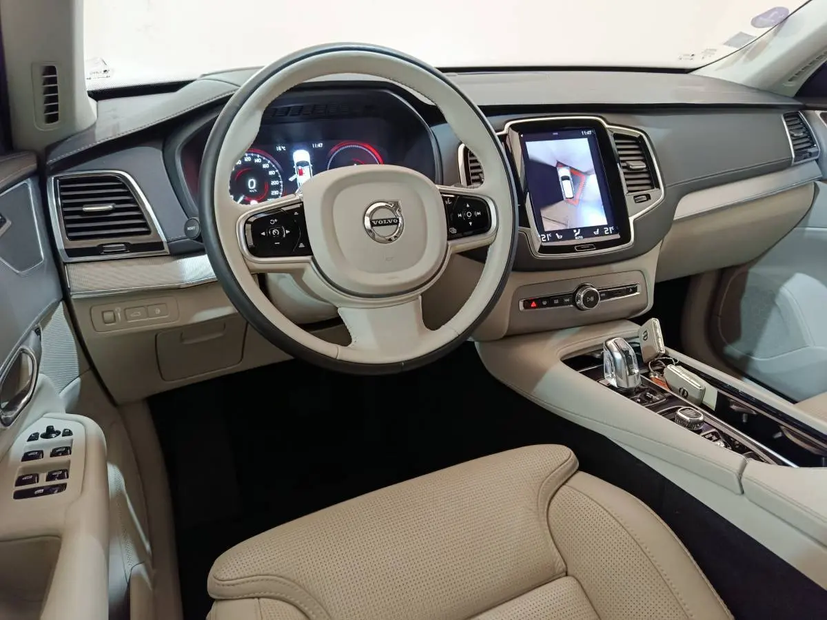 Intérieur beige clair du Volvo XC90 T8, vue depuis le siège conducteur sur volant et écran tactile central.
