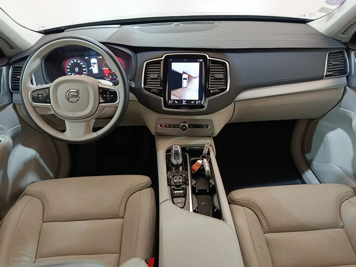 Intérieur beige clair du Volvo XC90 T8 2019 vu de face, avec tableau de bord numérique et écran tactile central.
