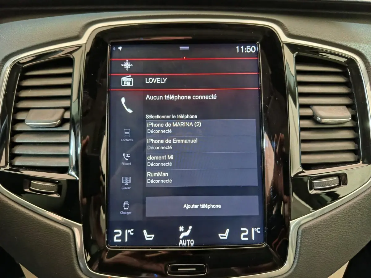 Écran tactile central du tableau de bord du Volvo XC90 gris clair, affichant les connexions Bluetooth et la climatisation à 21°C.