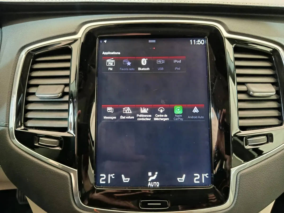 Écran tactile central du tableau de bord du Volvo XC90 gris clair, affichant les options multimédia et climatisation.