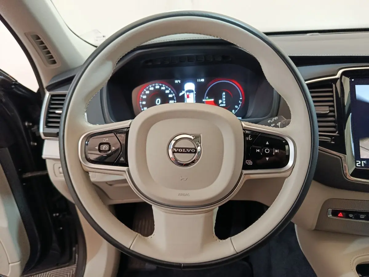 Volant beige du Volvo XC90 T8 2019 avec commandes multifonctions et tableau de bord numérique visible.