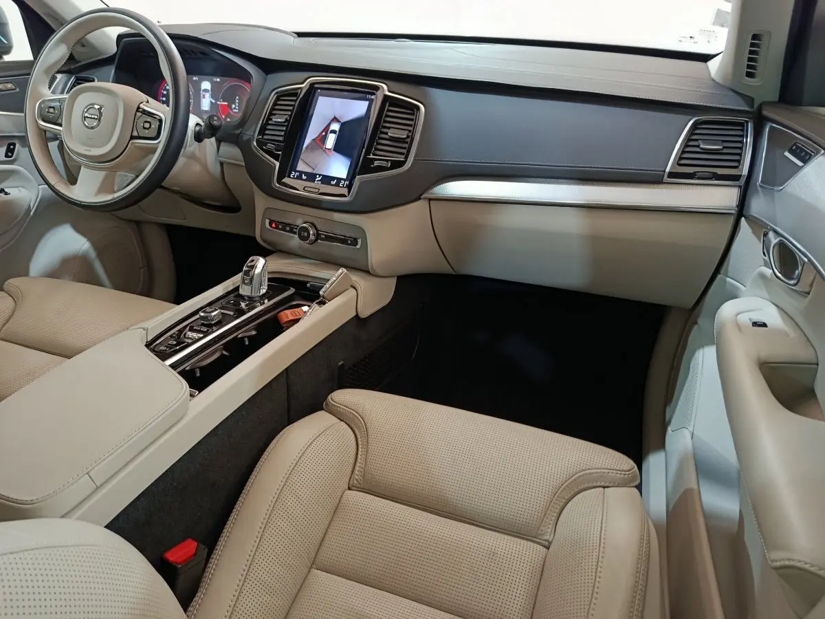 Intérieur beige clair du Volvo XC90 T8, vue côté passager avec console centrale et écran tactile en évidence.