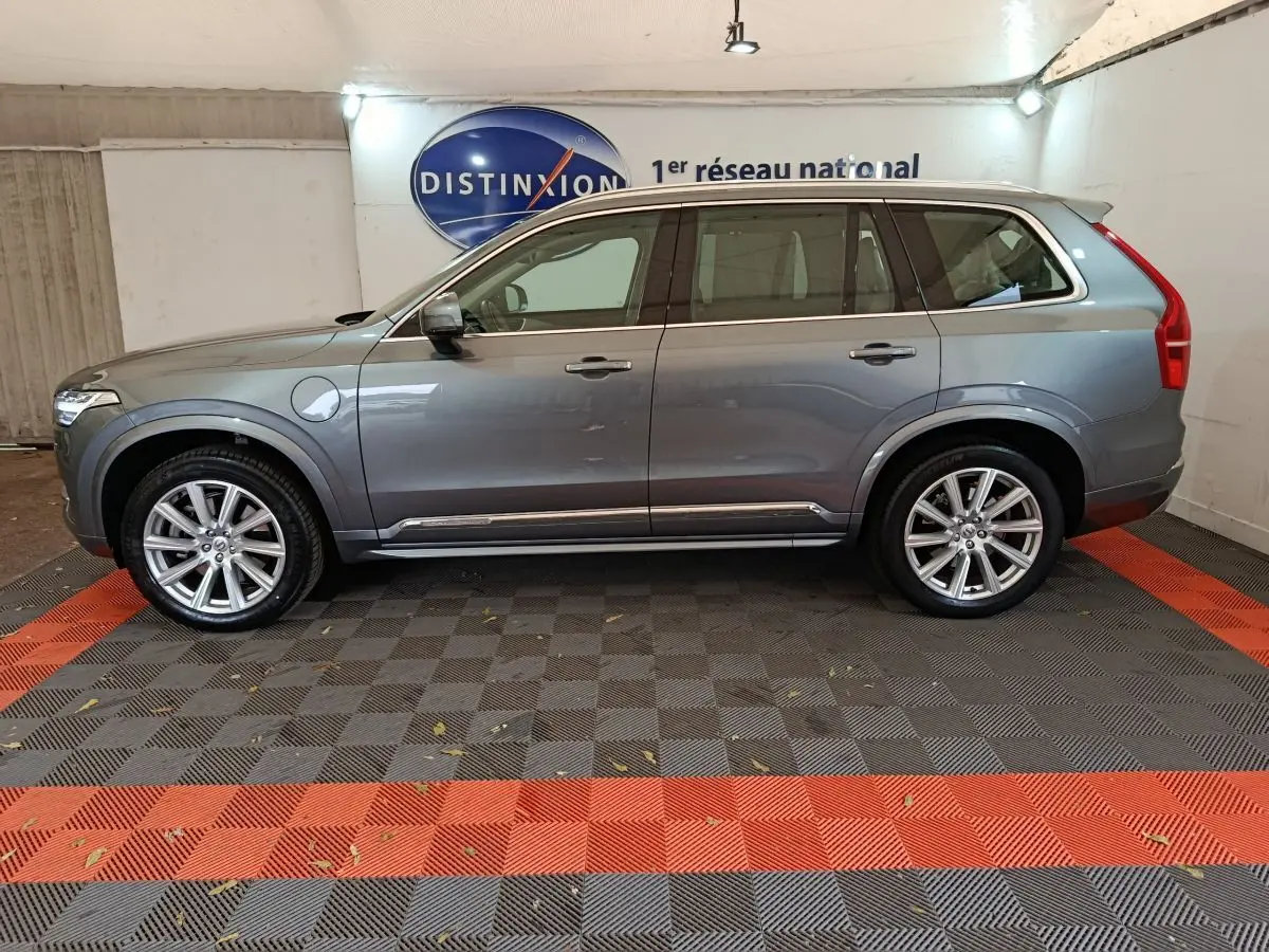 Profil côté gauche du Volvo XC90 gris clair hybride rechargeable, avec jantes alliage et toit ouvrant en verre visible.