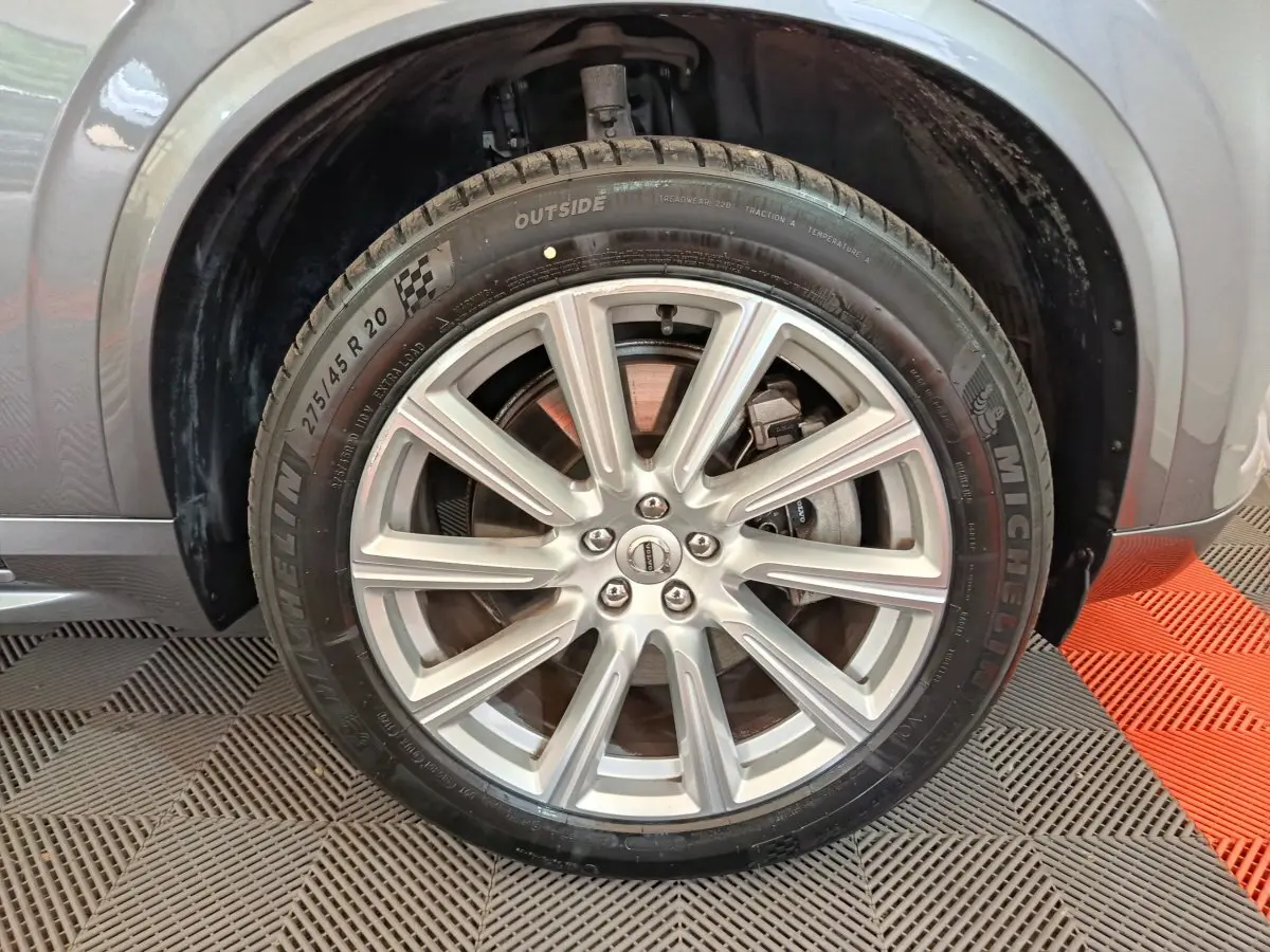 Gros plan sur la roue avant droite du Volvo XC90 gris clair, mettant en valeur la jante alliage et le pneu Michelin.