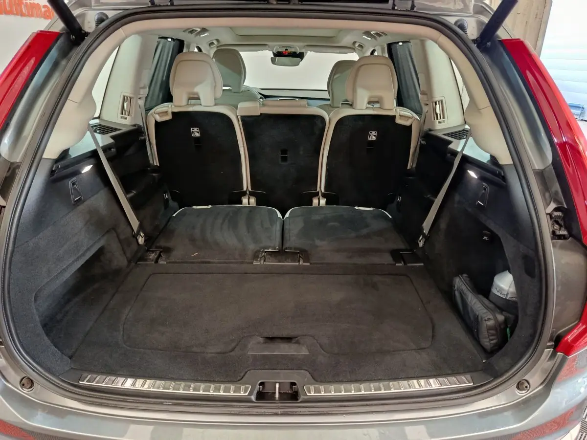 Coffre ouvert du Volvo XC90 gris clair, montrant la 3ème rangée de sièges rabattus et plancher plat.