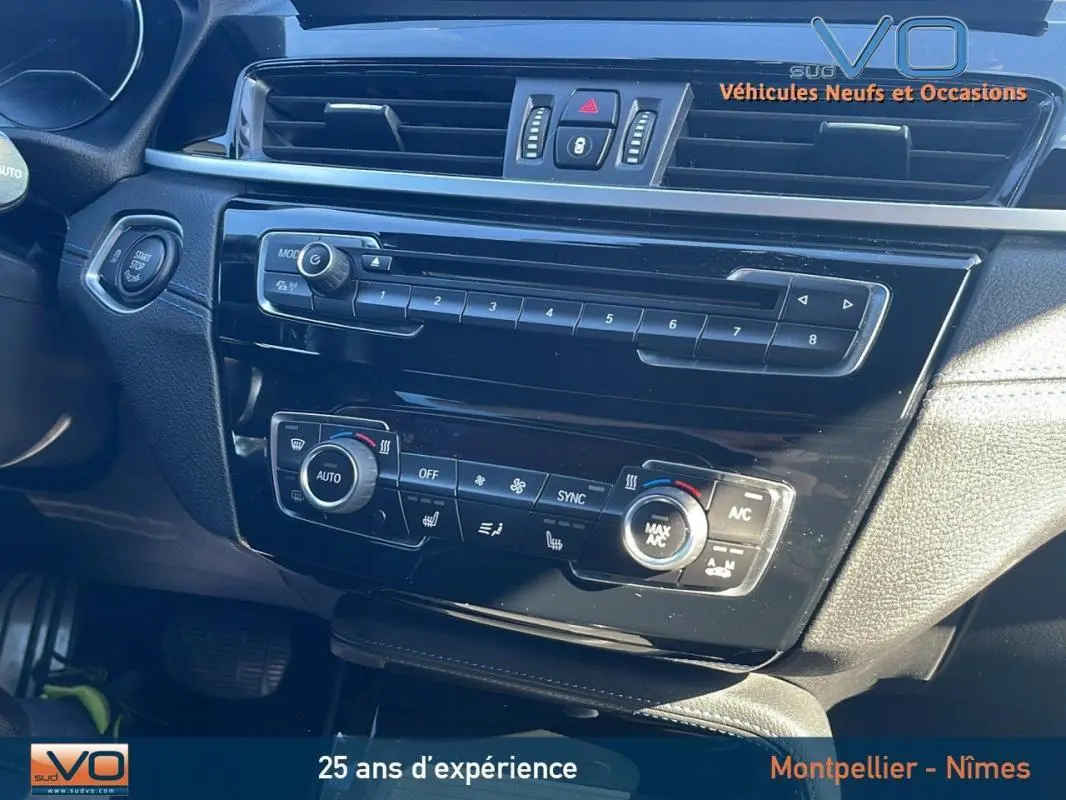 Tableau de bord noir brillant de BMW X2 F39 M35i 2019, avec commandes climatisation et démarrage sans clé visibles.