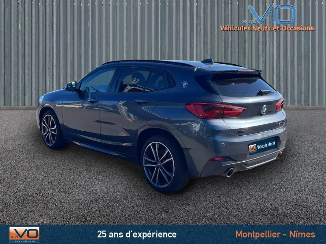 BMW X2 F39 M35i gris métallisé vu en 3/4 arrière droit, avec jantes alliage 19 pouces et double sortie d'échappement.