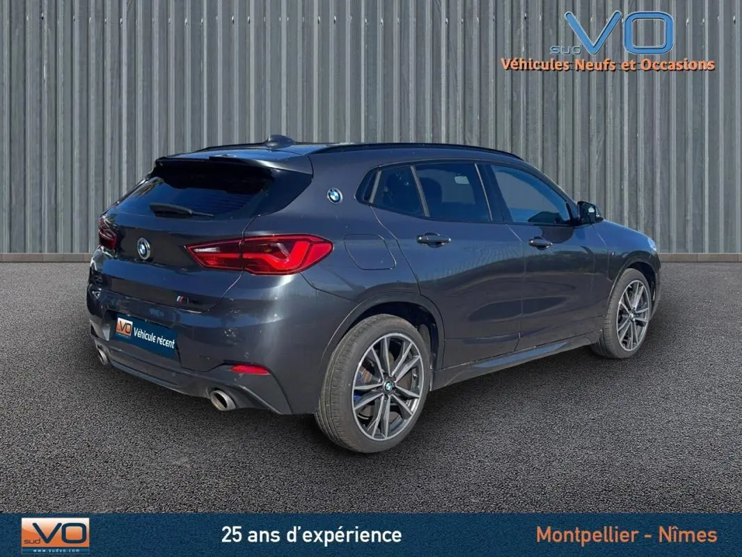 BMW X2 F39 M35i gris en 3/4 arrière droit, mettant en valeur ses jantes alliage 19 pouces et ses feux arrière LED.