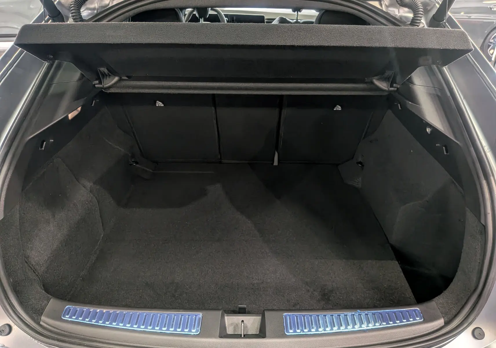 Coffre ouvert vu de l'arrière d'une Renault Rafale gris schiste satin, montrant un espace de chargement propre et spacieux.