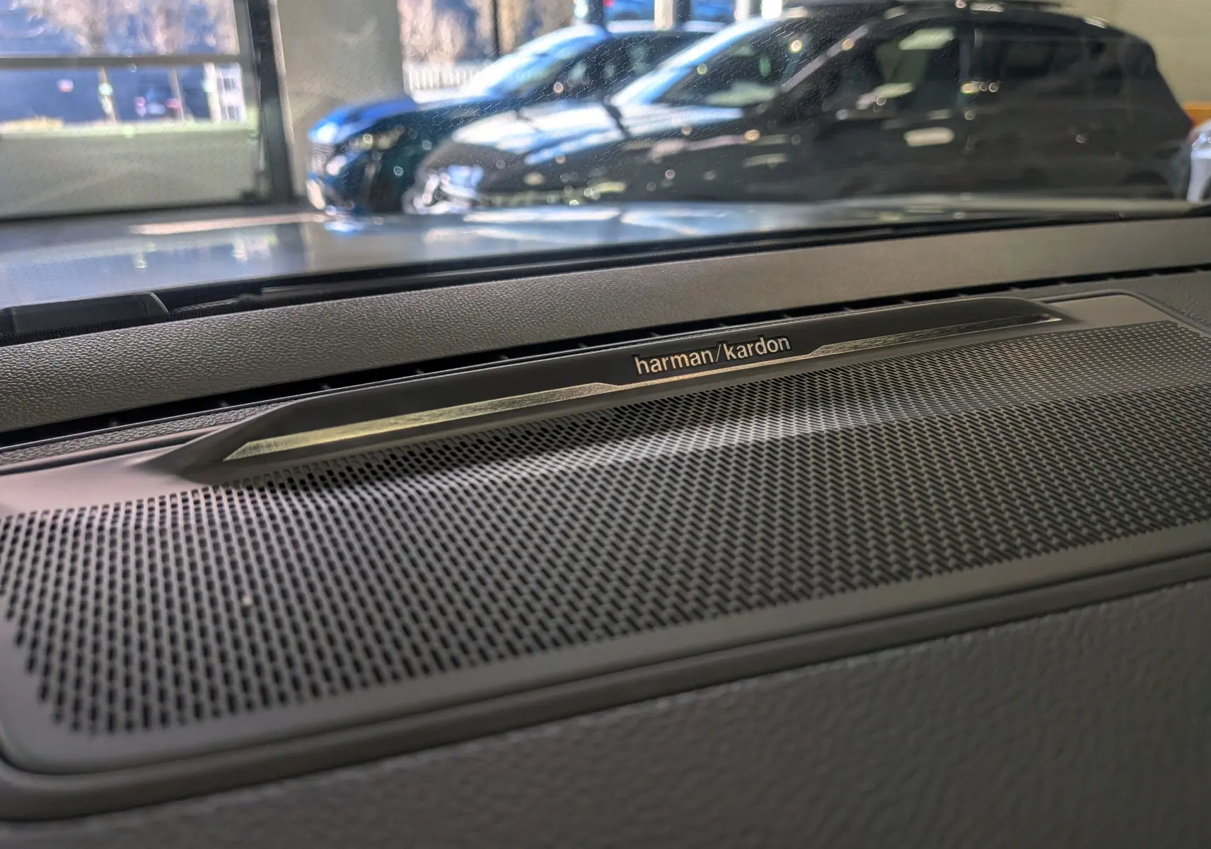 Gros plan sur la grille de haut-parleur Harman/Kardon intégrée au tableau de bord du Renault Rafale gris Schiste Satin.