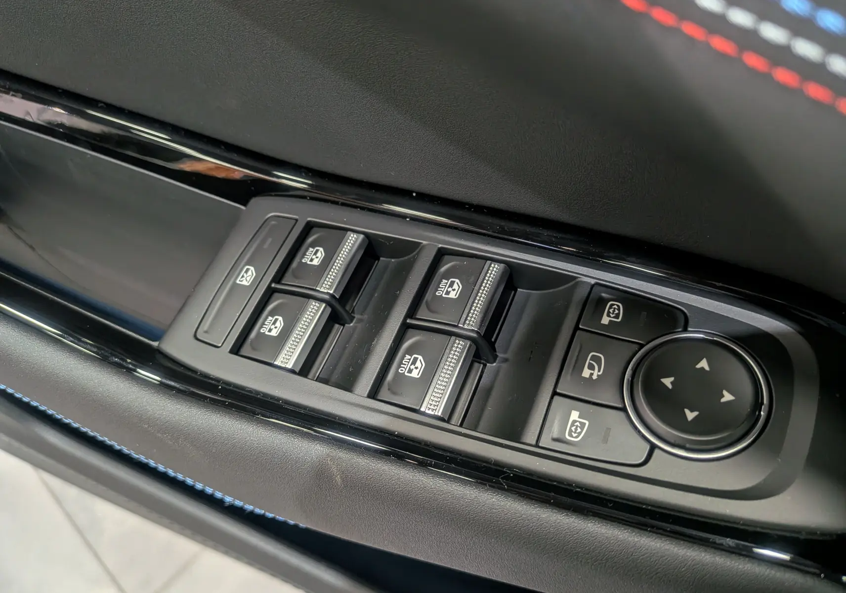 Gros plan sur les commandes des vitres électriques et rétroviseurs côté conducteur du Renault Rafale gris Schiste Satin.