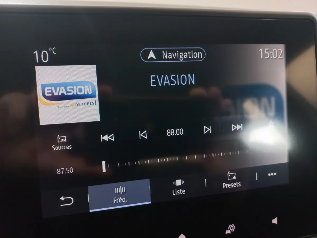 Écran tactile central de la Renault Clio blanc 2020 montrant la radio FM sur la fréquence 88.00 MHz à 15h02.