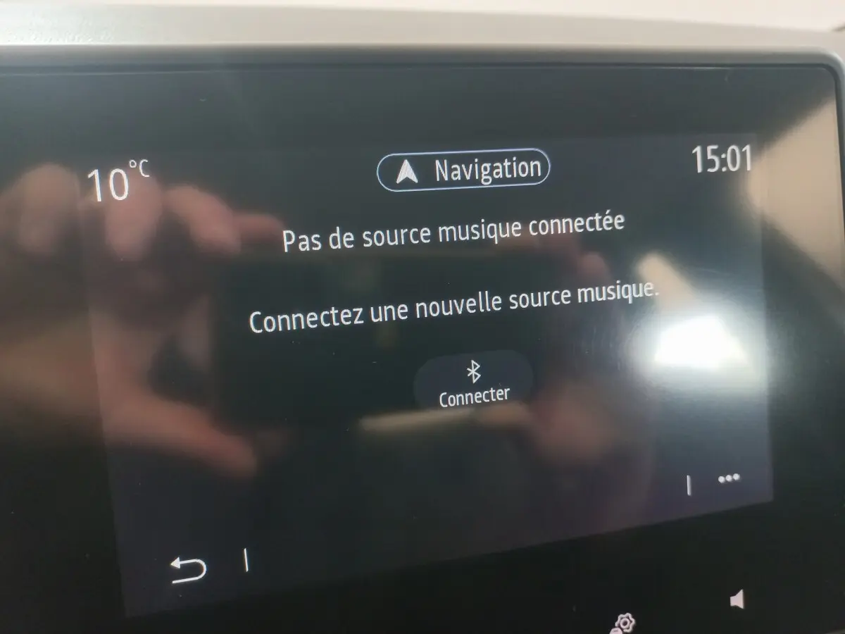 Écran tactile central de la Renault Clio blanc 2020 affichant le message de connexion Bluetooth pour la musique.
